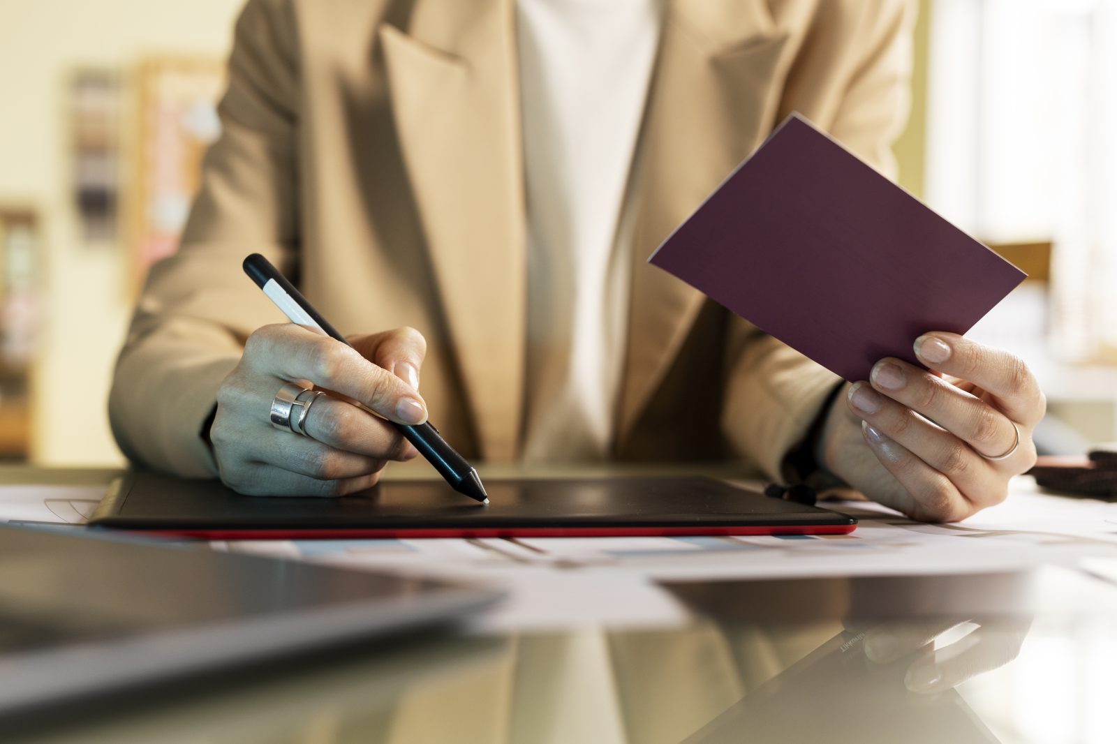 Hands signing a document beside a passport
